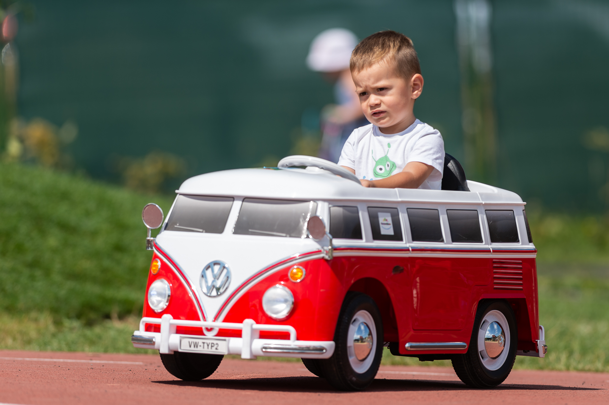 chlapček sediaci v detskom autíčku na detskom dopravnom ihrisku